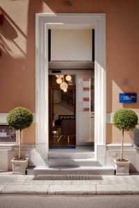 Tür zu einem Gebäude mit zwei Topfpflanzen in der Unterkunft Hotel Medinblu in Reggio di Calabria