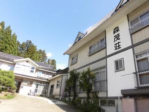 a white building with asian writing on it at Morishigesou in Myoko
