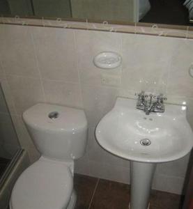 a bathroom with a white toilet and a sink at Hotel Real Estación in Bogotá