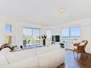 a white living room with a large white couch at Sunset at Snapper Point - Aldinga Beach - C21 SouthCoast Holidays in Aldinga Beach