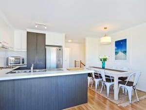 a kitchen and dining room with a table and chairs at Sunset at Snapper Point - Aldinga Beach - C21 SouthCoast Holidays in Aldinga Beach