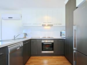 a kitchen with white cabinets and stainless steel appliances at Sunset at Snapper Point - Aldinga Beach - C21 SouthCoast Holidays in Aldinga Beach
