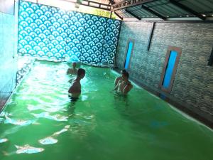 科欽的住宿－Palm Rivera Kochi，三个孩子在游泳池里