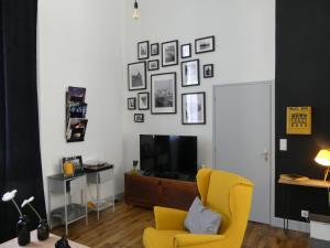 ソミュールにあるEntre Nous - La Posteのリビングルーム(黄色い椅子、テレビ付)