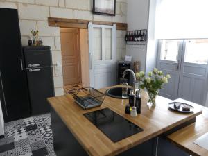 a kitchen with a wooden counter top with a sink at Entre Nous - La Poste in Saumur