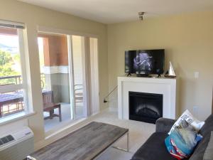 sala de estar con sofá y chimenea en 3 Bedroom Condo Steps to Lake & Stroll to Downtown, en Kelowna