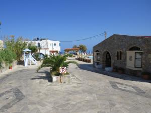 a building with a palm tree in the middle of a street at Blue Beach Villas Apartments in Stavros