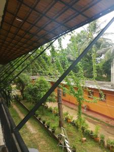 a view of a garden from a window at Walawe Park View Hotel in Udawalawe