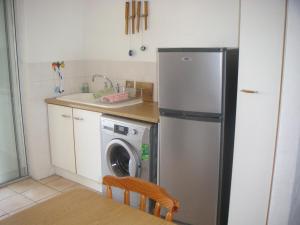 a kitchen with a refrigerator and a washing machine at Waterside Living DB03 in Jeffreys Bay