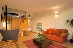 a living room with an orange couch and a table at O Vale in Ericeira