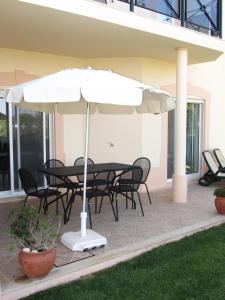 a table and chairs under an umbrella on a patio at Fairviews Villa on Boavista Golf Resort in Lagos