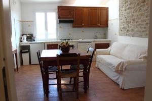 a kitchen with a table and a living room with a couch at Agriturismo Re Piano in Modigliana