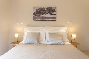 a bedroom with a white bed with white pillows at Àstanza in Castellabate