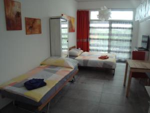 a room with two beds and a table and a desk at Elisa in Solothurn
