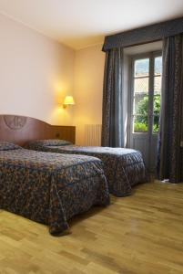 a hotel room with two beds and a window at Albergo Italia in Varallo