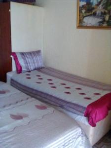 - une chambre avec 2 lits avec des draps roses dans l'établissement Guest House Macauly, à Johannesbourg