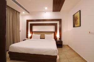 ein Schlafzimmer mit einem großen Bett mit zwei Nachttischen in der Unterkunft Grand Hotel Nawanshahr in Nawāshahr