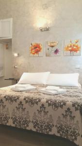 a bed in a bedroom with paintings on the wall at Marcelina vaticans rooms in Rome