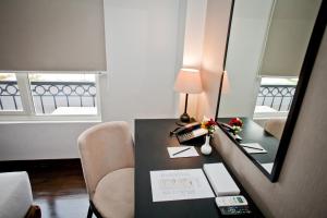 a room with a desk with a lamp and a mirror at Samala Hotel Jakarta Cengkareng in Jakarta