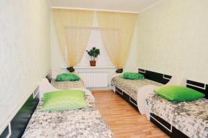 ジヴェエヴォにあるApartment on Chkalova 2dのベッド3台(緑の枕付)が備わる客室です。