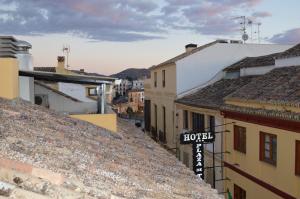 un panneau de rue au-dessus des toits des bâtiments dans l'établissement Hotel Don Javier, à Ronda