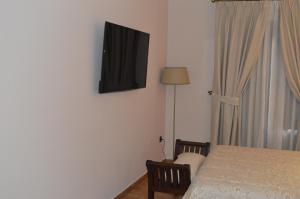 a bedroom with a bed and a television on the wall at Hotel Don Javier in Ronda