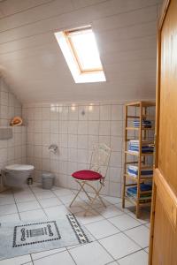 a bathroom with a red chair and a toilet at Ferienhaus Marie in Bremm