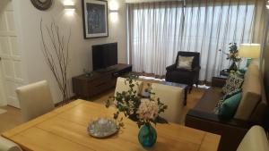 a living room with a table and a couch at Batu Ferringhi Seaview Apartment in Batu Ferringhi