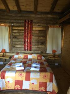 a bedroom with a bed in a log cabin at Enkel Cabañas in José de la Quintana