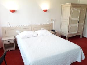 
a bedroom with a bed and a dresser at Au Nouvel Hôtel in Toulon
