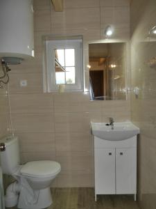 ein Badezimmer mit einem weißen WC und einem Waschbecken in der Unterkunft Chatki Niwki u Zbója in Krościenko nad Dunajcem
