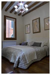una camera da letto con un grande letto e un lampadario a braccio di Domus Dea a Venezia