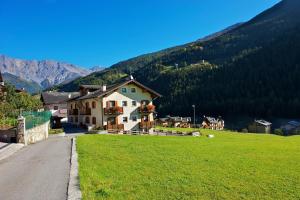 a house in a field with mountains in the background at Casa Sofia in Valdisotto