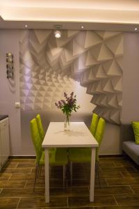 a dining room with a table and green chairs at APARTAMENTY Kolonia Leśna in Wünschelburg