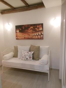 ボローニャにあるLa Petroniana Homeの壁画のある部屋の白いソファ