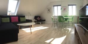 uma sala de estar com um sofá, uma mesa e cadeiras em Vejle Apartment Skovhøjen em Vejle