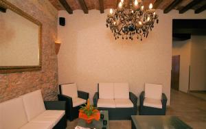 a waiting room with chairs and a chandelier at Parrots Sitges Hotel in Sitges