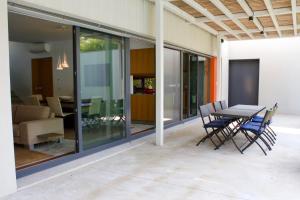 a patio with a table and chairs in a house at Design House Aroeira Golf in Charneca
