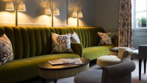 a living room with a green couch and chairs at The Queensberry Hotel in Bath