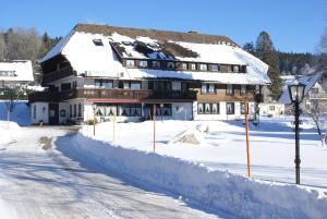 un edificio cubierto de nieve con una carretera delante en SchöpPerle en Häusern