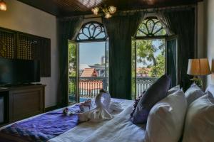 a bedroom with a bed with a large window at 5 Heeren Museum Residence in Melaka