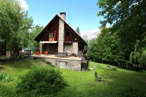 una casa de piedra con techo de paja en un patio en Chalet Pegulu, en Puy-Saint-Vincent