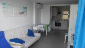 a living room with a white couch and blue pillows at Apartamento Mediterráneo in Rincón de la Victoria +15 photos