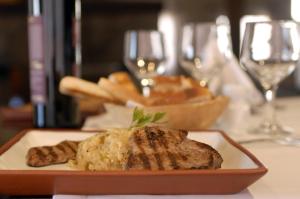 a plate of food on a table with wine glasses at Hotel de Las Nubes in San Antonio de los Cobres