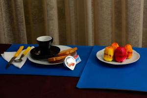 a table with two plates of fruit and a cup of coffee at Terrazzo su Ibla in Ragusa +13 photos