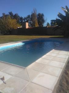 una piscina de agua azul en un patio en La Casita De Lunlunta en Luján de Cuyo