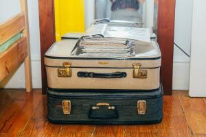 two suitcases stacked on top of each other on the floor at Dona Fina Guest House in Mirandela