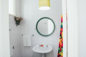 a white bathroom with a sink and a mirror at Dona Fina Guest House in Mirandela +63 photos
