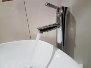 un fregadero con agua saliendo de un grifo en La Signature Guest house, en Francistown 15 fotos más