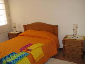 ein Schlafzimmer mit einem orangenen Bett und zwei Nachttischen in der Unterkunft Intheminhohouse in Amorosa